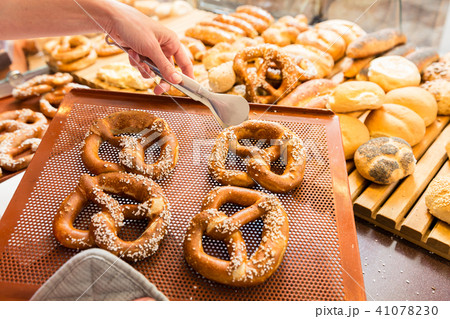 Sales lady in bakery shop selling pretzels and bread Sales lady in bakery shop selling pretzels and bread 41078230
