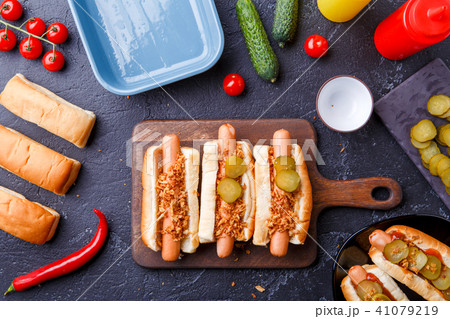 Picture on top of buns with sausages on cutting board, on table with cucumbers Picture on top of buns with sausages on cutting board, on table with cucumbers 41079219