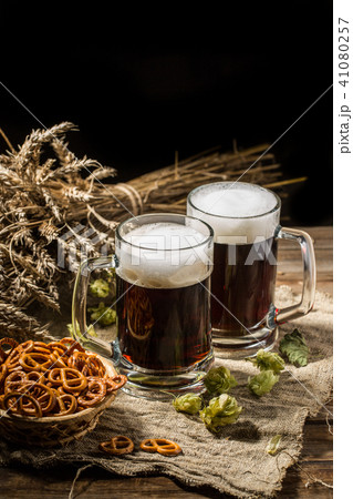 Couple beer mug with hop and pretzels on linen cloth Couple beer mug with hop and pretzels on linen cloth 41080257