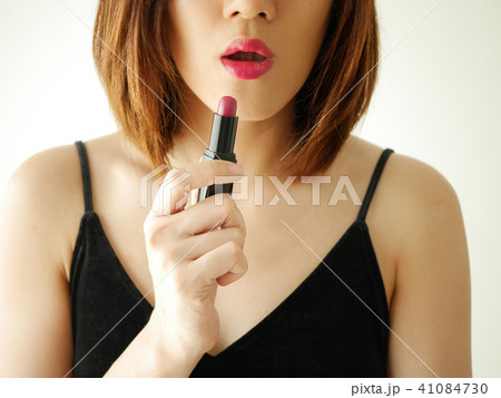 portrait young woman applying or wearing lipstick, red ,pink ,ma 41084730