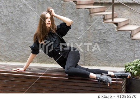 The girl is lying on the bench. 41086570