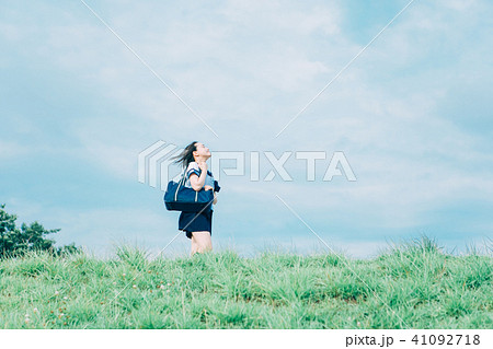 河川敷を歩く女子高生の写真素材