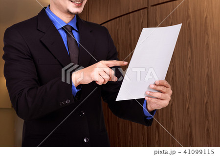 Businessman standing with paperwork 41099115
