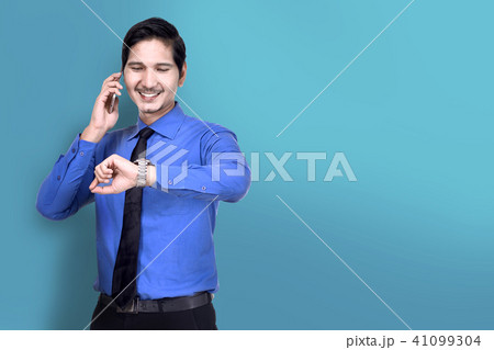 Businessman check the watch while talking on phone Businessman check the watch while talking on phone 41099304