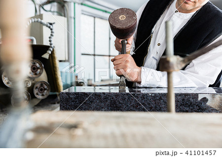 Stone mason working on tombstone in workshop Stone mason working on tombstone in workshop 41101457