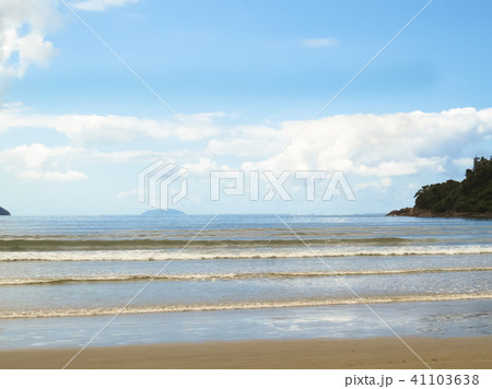 View of beach with waves and island. 41103638