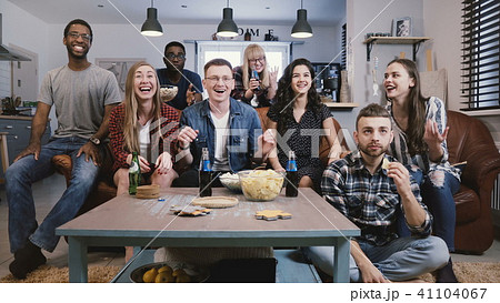 Mixed race friends watch sports on TV. Student football fans supporters get upset. Cheering for 41104067