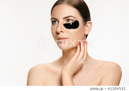 Young beautiful woman applying a mask for the face of the therapeutic black mud. Spa treatment Young beautiful woman applying a mask for the face of the therapeutic black mud. Spa treatment 41104532