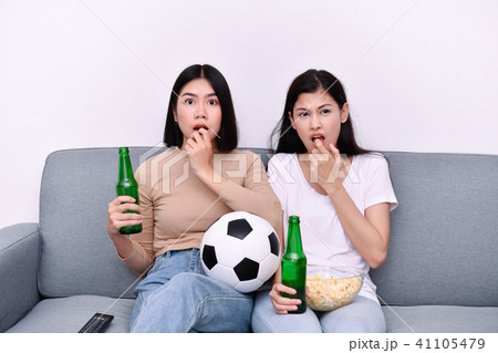Concept of cheering. Asian teenagers watching football on televi Concept of cheering. Asian teenagers watching football on televi 41105479
