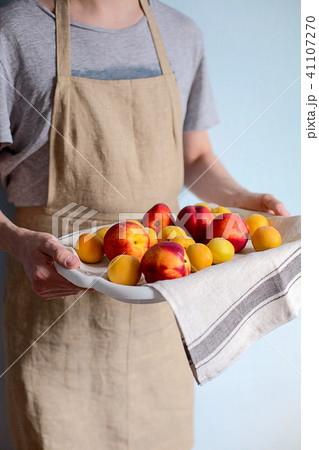A man holds a tray with apricots and nectarines A man holds a tray with apricots and nectarines 41107270