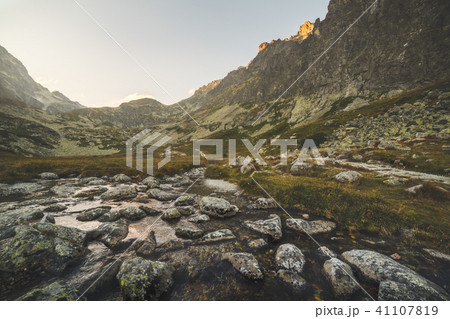 Creek in the Valley under the Mountain Peaks 41107819