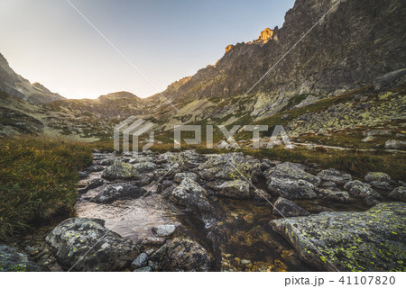 Creek in the Valley under the Mountain Peaks 41107820
