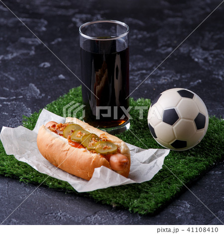 Photo of glass of beer, green grass with soccer ball, hotdog Photo of glass of beer, green grass with soccer ball, hotdog 41108410