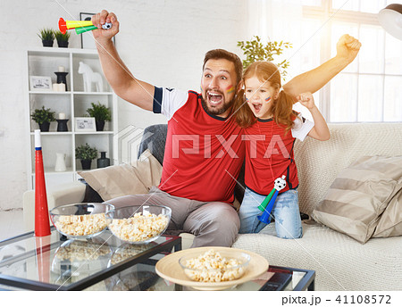 family of fans watching a football match on TV family of fans watching a football match on TV 41108572
