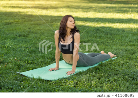 Woman practicing yoga outdoors in park Woman practicing yoga outdoors in park 41108695