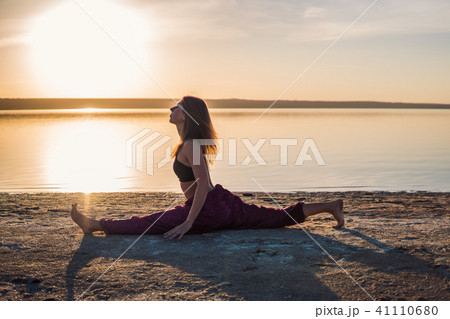 Silhouette yoga woman on the beach at sunset. Silhouette yoga woman on the beach at sunset. 41110680