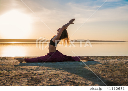 Silhouette yoga woman on the beach at sunset. Silhouette yoga woman on the beach at sunset. 41110681
