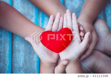 Red heart in child and parent hands with love 41111506