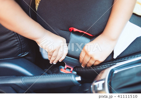 child is fastening security belt by herself 41111510