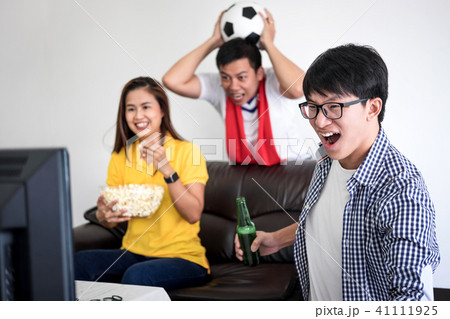 Group of friends fanclub watching soccer match on tv and cheerin Group of friends fanclub watching soccer match on tv and cheerin 41111925