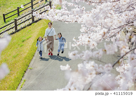 桜の咲く公園を歩く母と子 41115019