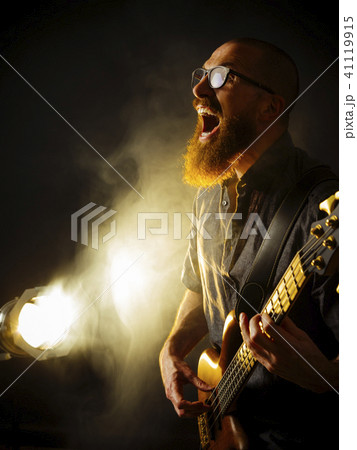Screaming bass player in front of spotlight 41119915