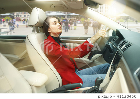 Driving around city. Young attractive woman driving a car 41120450