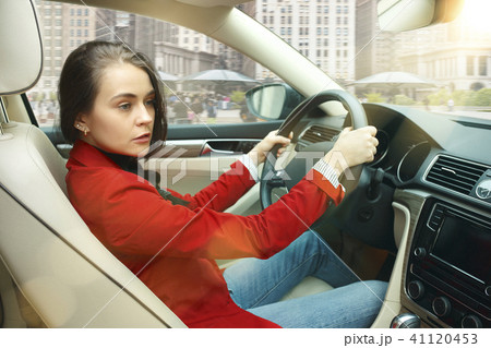 Driving around city. Young attractive woman driving a car 41120453