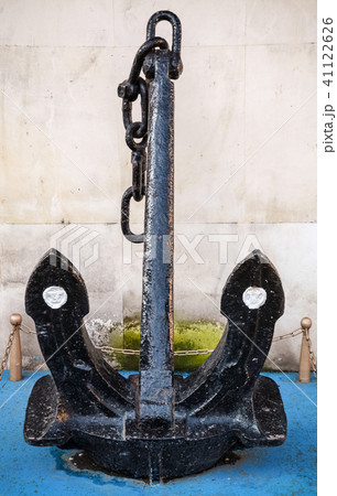 Big black anchor stands near wall in port Big black anchor stands near wall in port 41122626