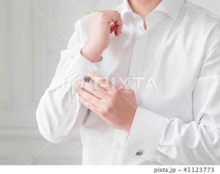 Man in white shirt adjusts his cufflinks. Man in white shirt adjusts his cufflinks. 41123773