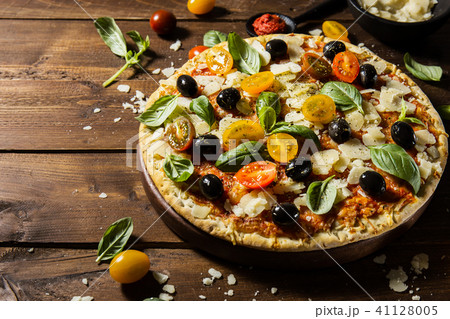 Traditional italian pizza on wooden table Traditional italian pizza on wooden table 41128005
