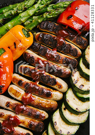 Sausages with sauce and vegetables on frying pan 41128331