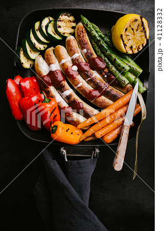 Sausages with sauce and vegetables on frying pan 41128332