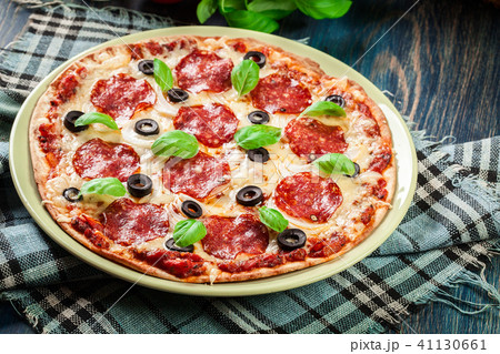 Pizza pepperoni with olives served Pizza pepperoni with olives served 41130661