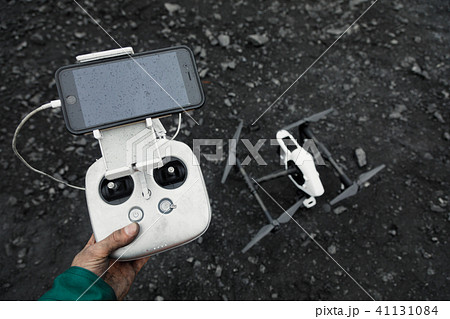 Man with remote control prepare white drone with digital camera for start flying. Man with remote control prepare white drone with digital camera for start flying. 41131084