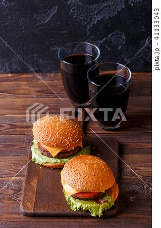 Photo of two fresh hamburgers and two glasses of juice Photo of two fresh hamburgers and two glasses of juice 41133043
