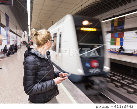 Woman with a cell phone waiting for metro. 41133442