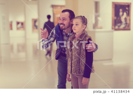 Father and small daughter exploring paintings in halls 41138434