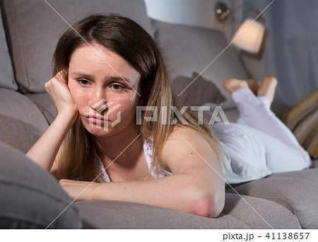Young female is thoughtful and bored alone Young female is thoughtful and bored alone 41138657