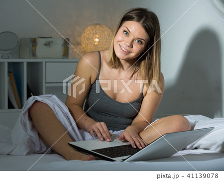 Portrait of sexy positive woman sitting with laptop in bed Portrait of sexy positive woman sitting with laptop in bed 41139078