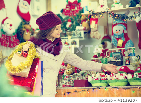 Beautiful happy woman choosing Christmas decoration Beautiful happy woman choosing Christmas decoration 41139207