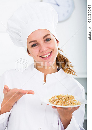 Girl cook shows plate of porrige Girl cook shows plate of porrige 41139245