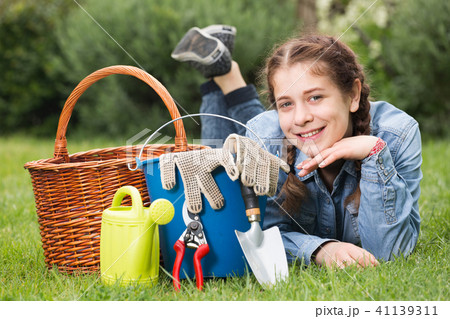 female with gardening tools while lying in park female with gardening tools while lying in park 41139311