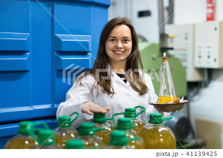 Portrait of female posing with olive oil containers Portrait of female posing with olive oil containers 41139425