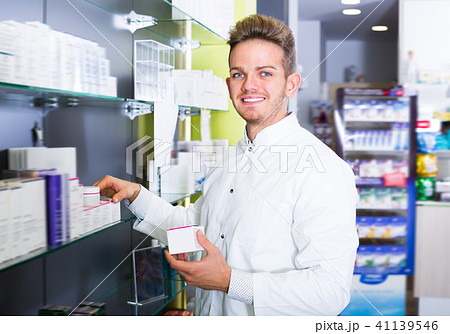 Happy pharmacist standing among shelves Happy pharmacist standing among shelves 41139546