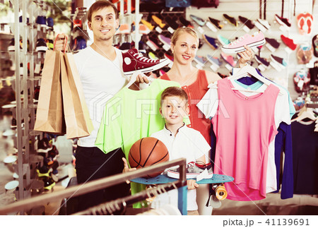 Cheerful adult parents with boy in sport store 41139691