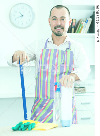 Young man in apron cleaning table Young man in apron cleaning table 41139696