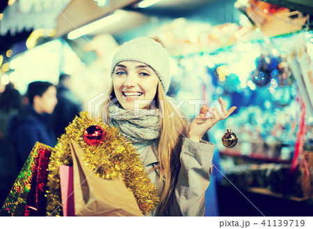 Girl choosing Christmas gifts outdoor. Girl choosing Christmas gifts outdoor. 41139719