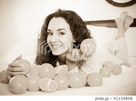 Positive girl eating oranges in bed 41139808