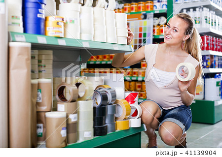 cheerful woman customer choosing adhesive tape in household store 41139904